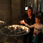 Kim and Sydney lighting a candle in Notre Dame
